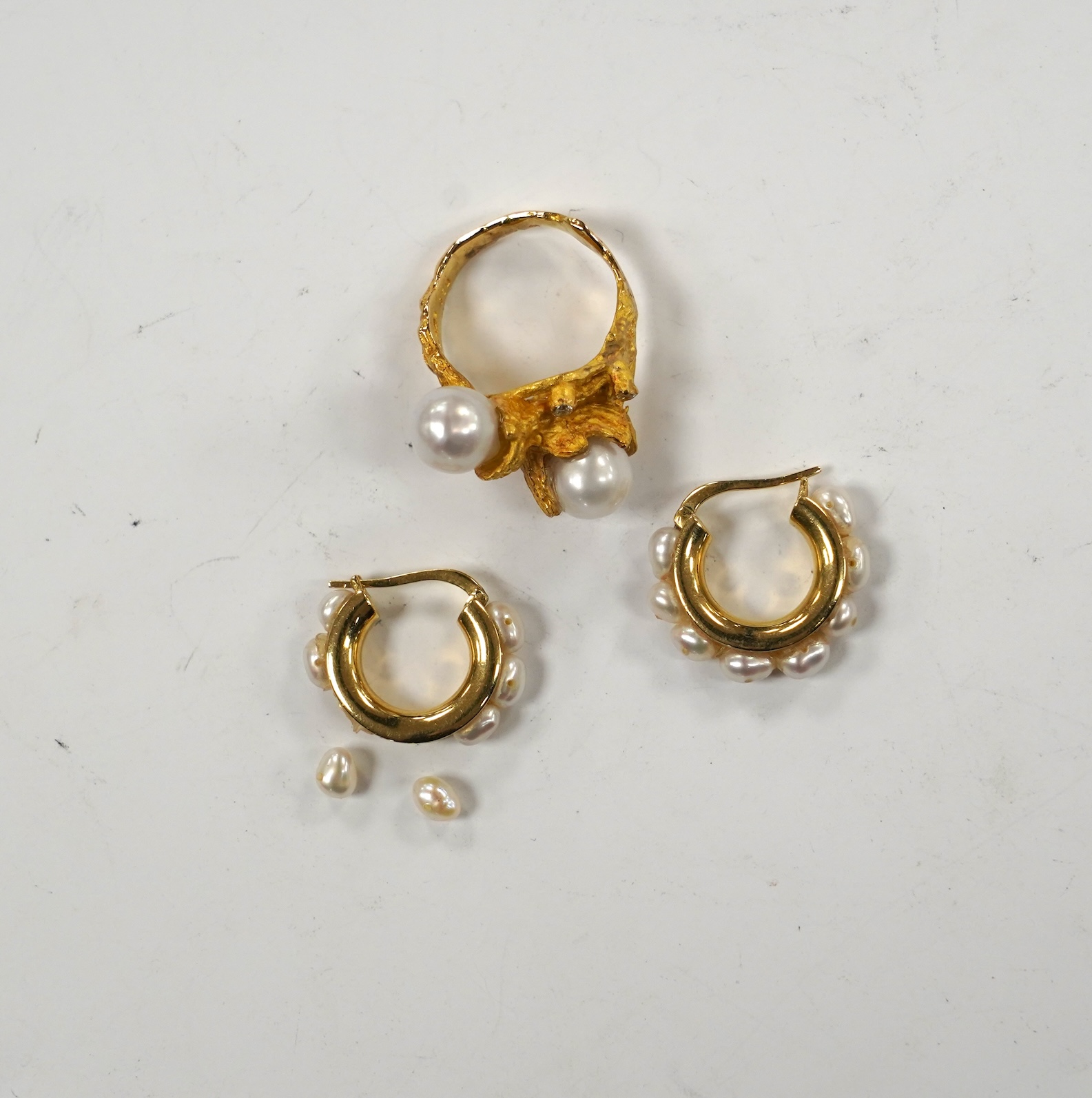 A recent 750 yellow metal two stone cultured pearl and three stone diamond chip set modernist ring, size M/N, gross 9.7 grams and a pair of baroque pearl set half hoop earrings (a.f.).